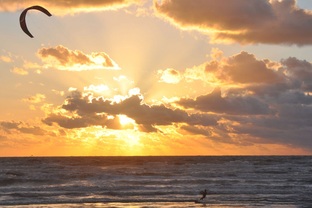 Kitesurfer tijdens zonsondergang