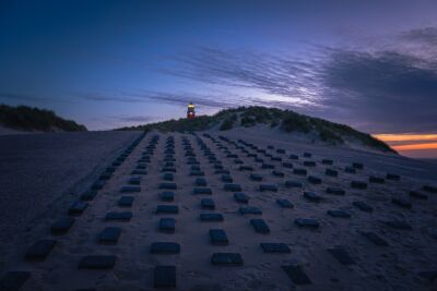 De vuurtoren morgenvroeg van het strand op Texel