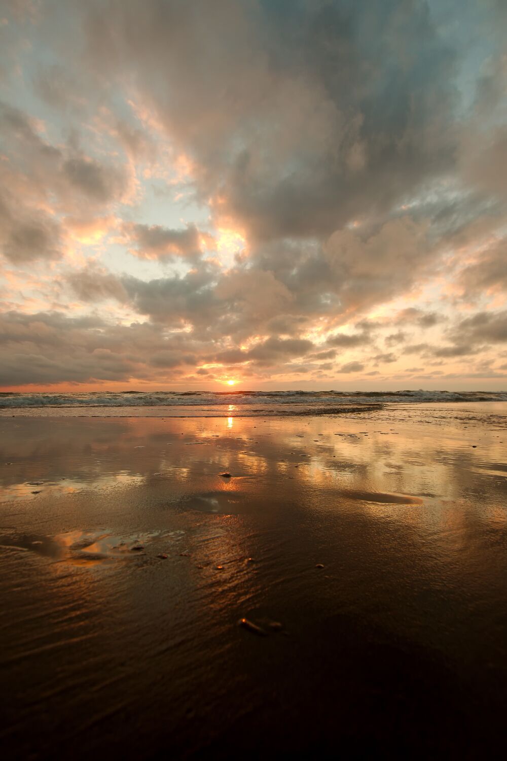 Imposante wolkenlucht bij zonsondergang aan het noordzeestrand op Texel