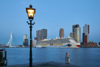 Cruiseschip voor de skyline van Rotterdam