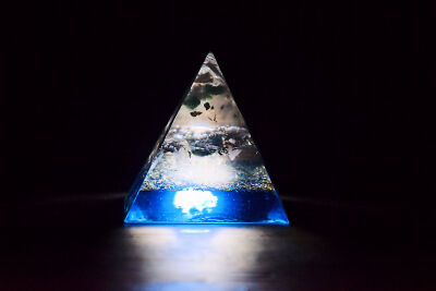 Een orgonite pyramide in het licht en donker
