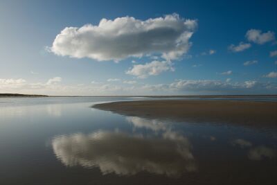 Wolk spiegelt zich in de zee