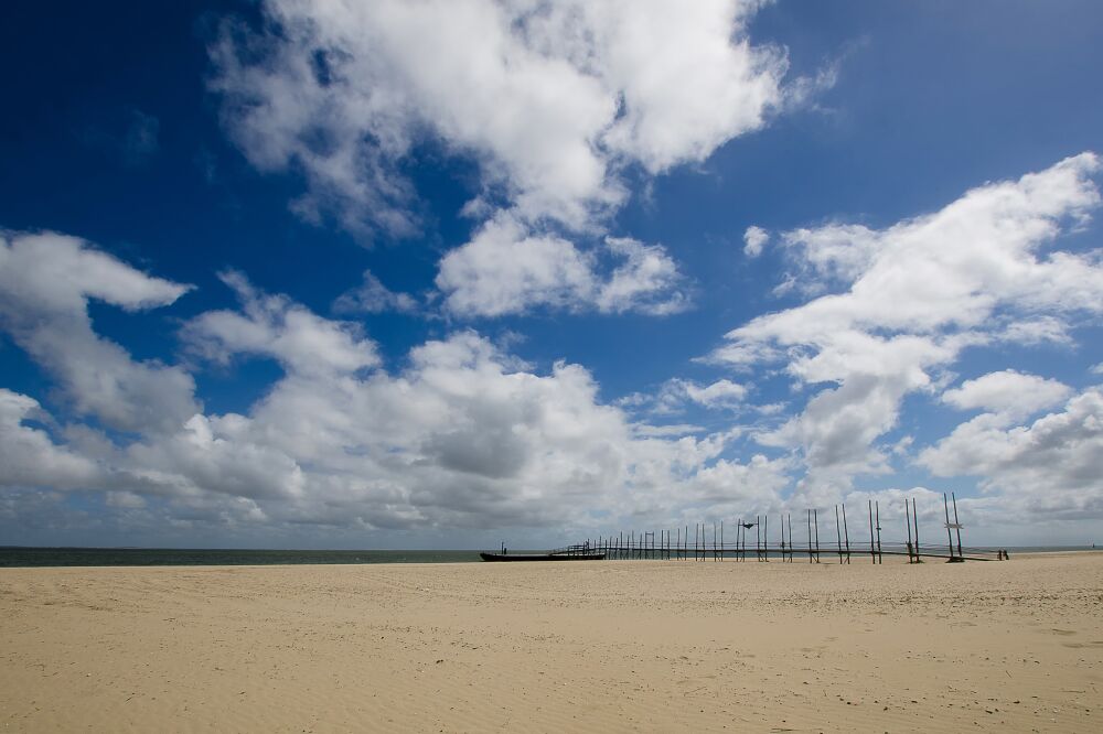 De steiger van het waddenveer in de winter op het uitgestrekte strand van Texel