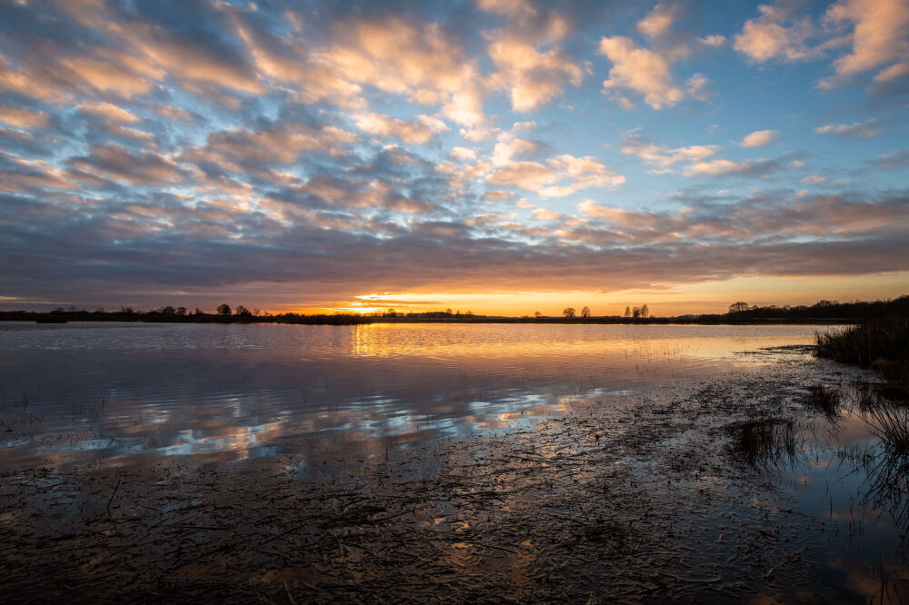 Zonsondergang met wolken boven het water