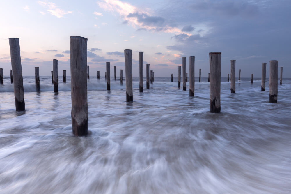 Golven tussen de palen in de zee bij Petten