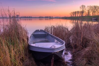 Zonsopkomst met een bootje aan het water