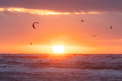 Kitesurfer tijdens zonsondergang