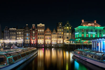 Het Damrak te Amsterdam in de avond