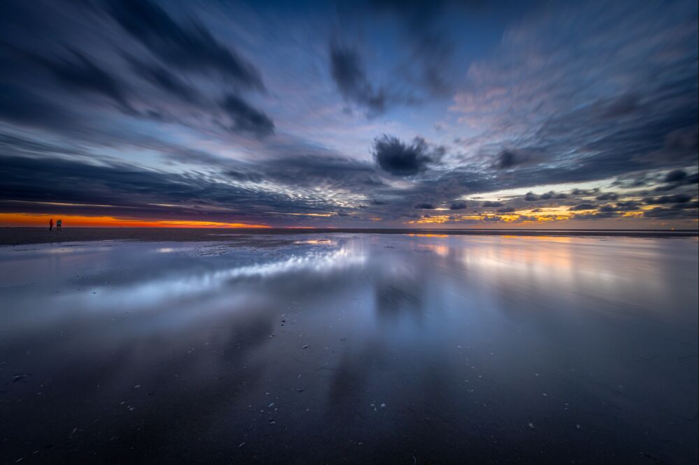 Weerspiegeling van de avondlucht op het strand