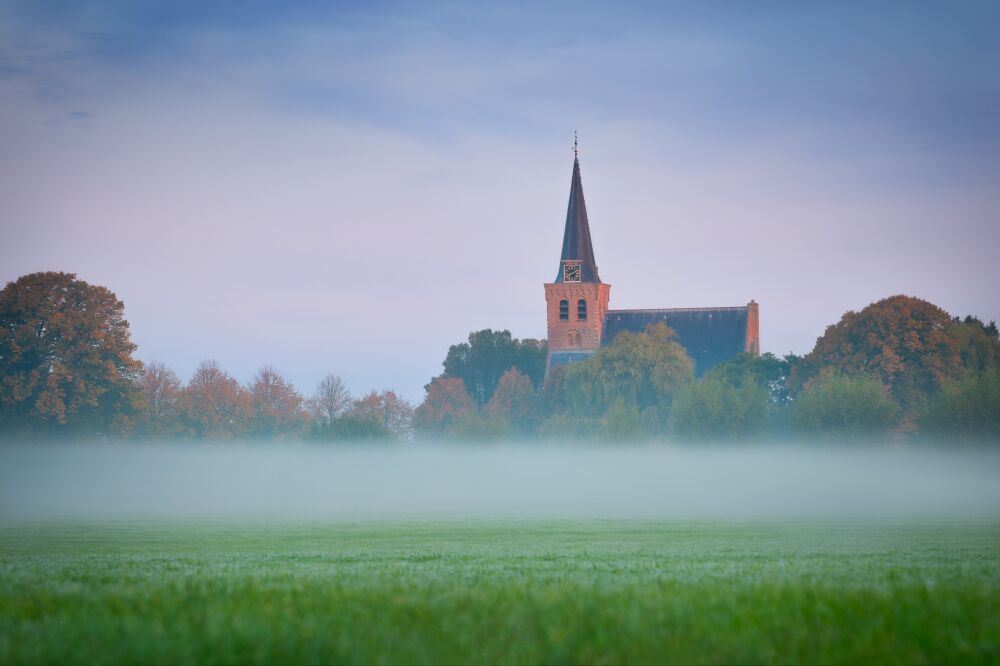 Sereen Dorpskerkje in de Ochtendmist