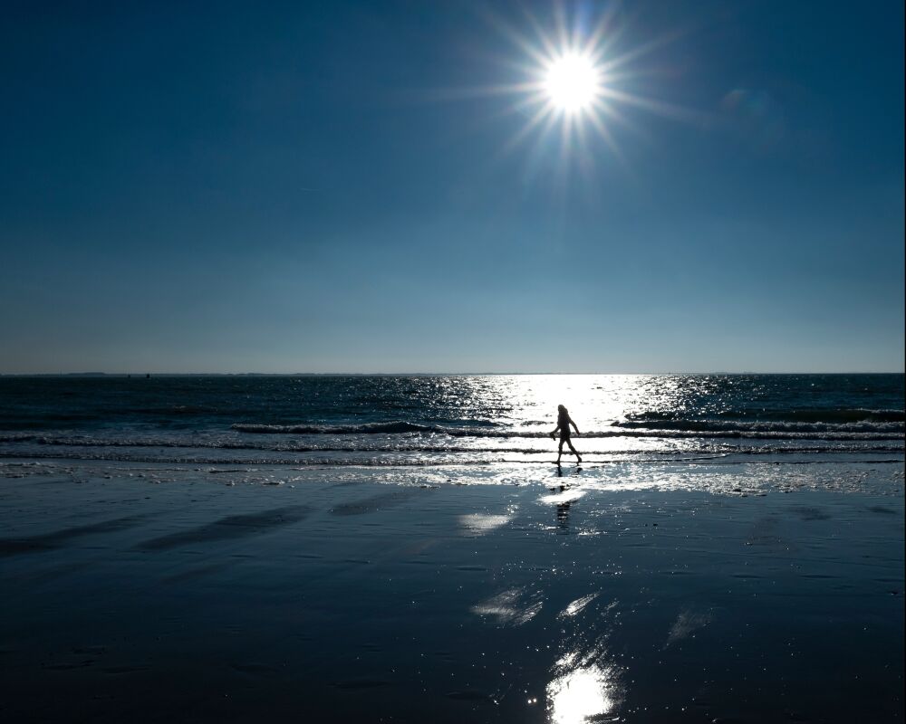 wandelaar aan zee in het tegenlicht