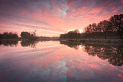 Roze hemel boven een spiegelend landschap