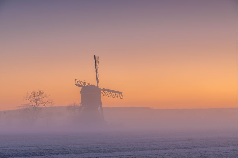 Ochtendgloed over de mistige molen