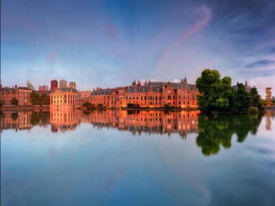 Avondlicht over het binnenhof en reflecties in de hofvijver.