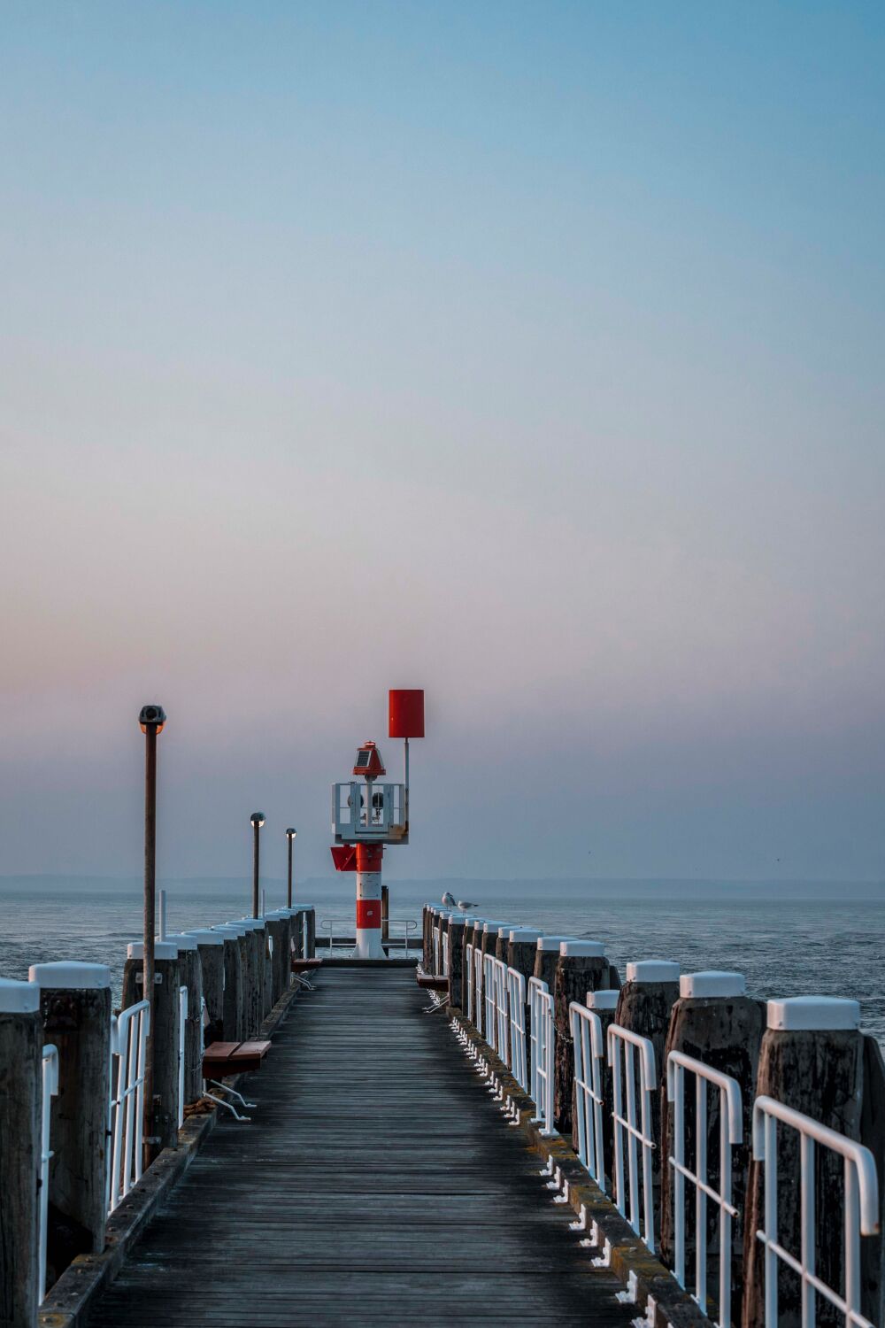 Eindeloze Horizon - Verlichte Vuurtoren op een Stille Pier