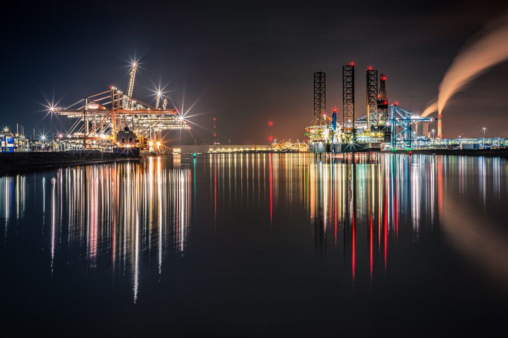 Industrial night photography of the harbour with reflections on the water