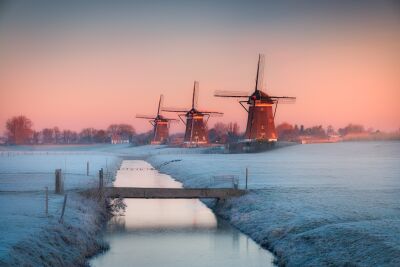 Winterse molens bij zonsopgang in een bevroren landschap