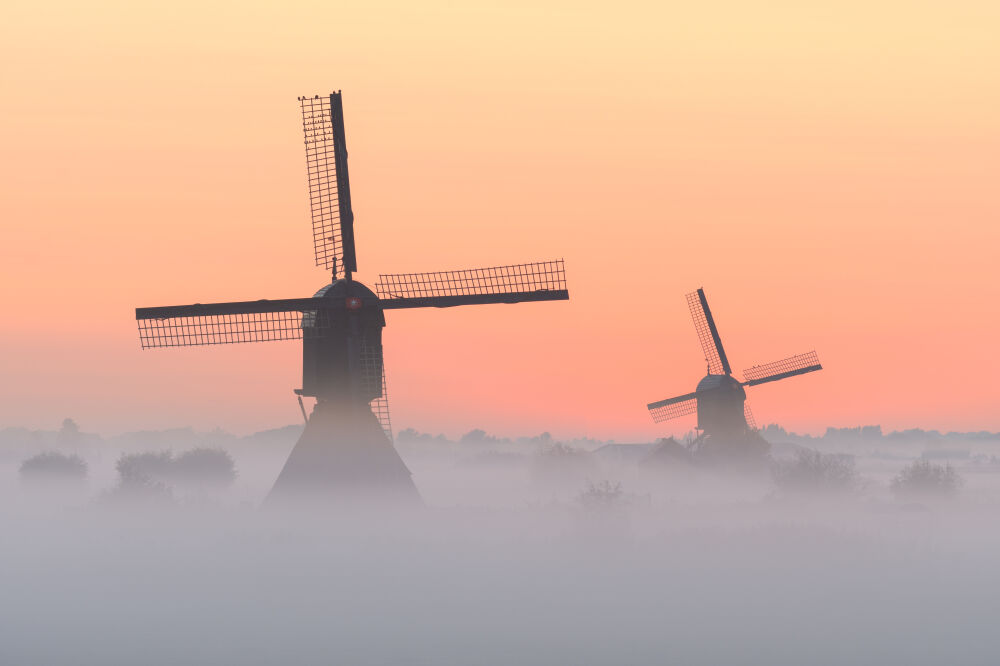 Molens in de mist tijdens zonsopkomst