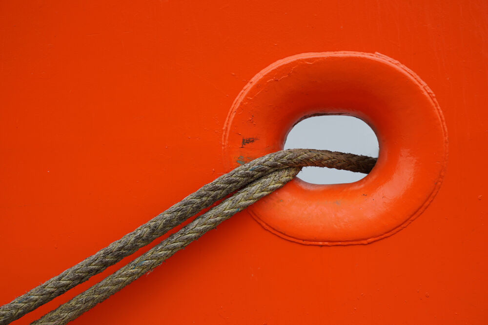 Oranje scheepswand met touw.