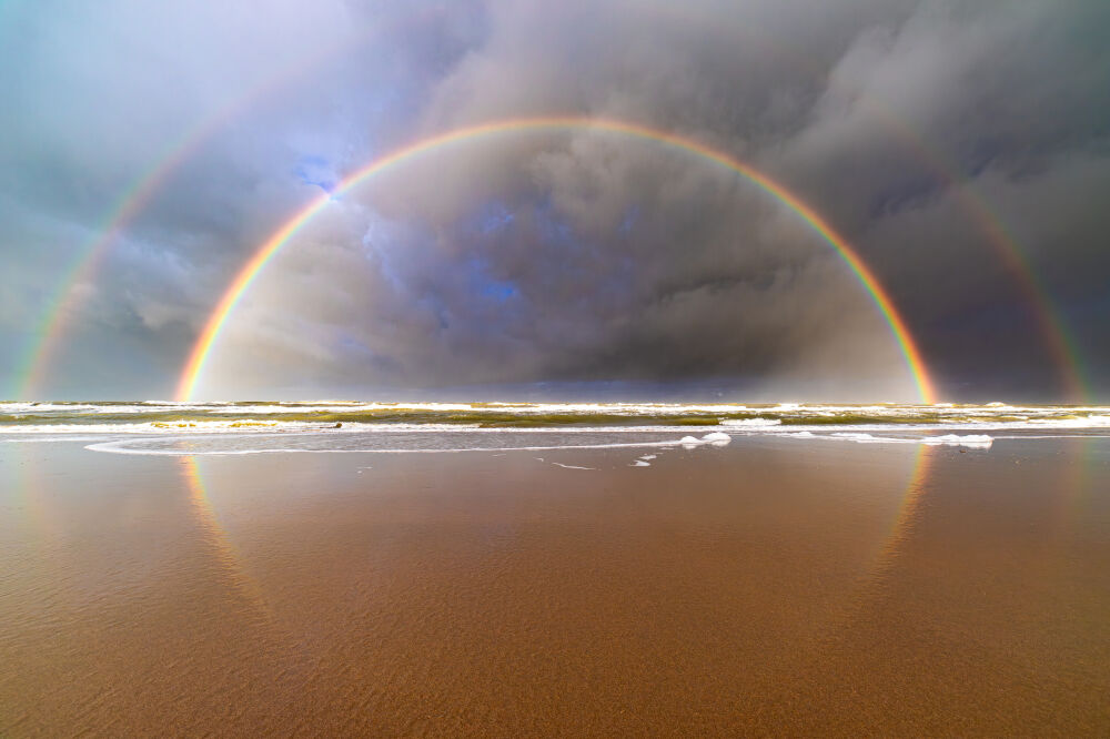 Dubbele regenboog met reflectie