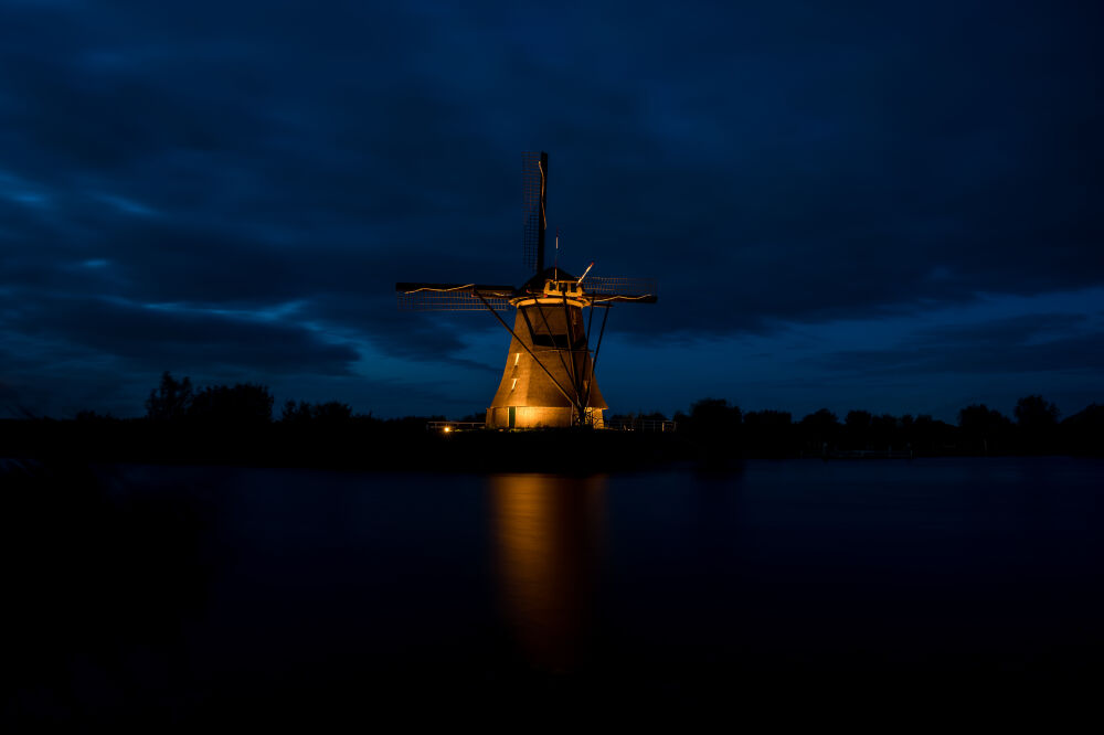 Verlichte Kinderdijk met dreigende wolken