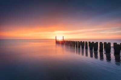 Kleurrijke horizon bij zonsondergang met pier aan zee