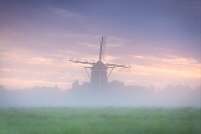 Mystical windmill in morning mist