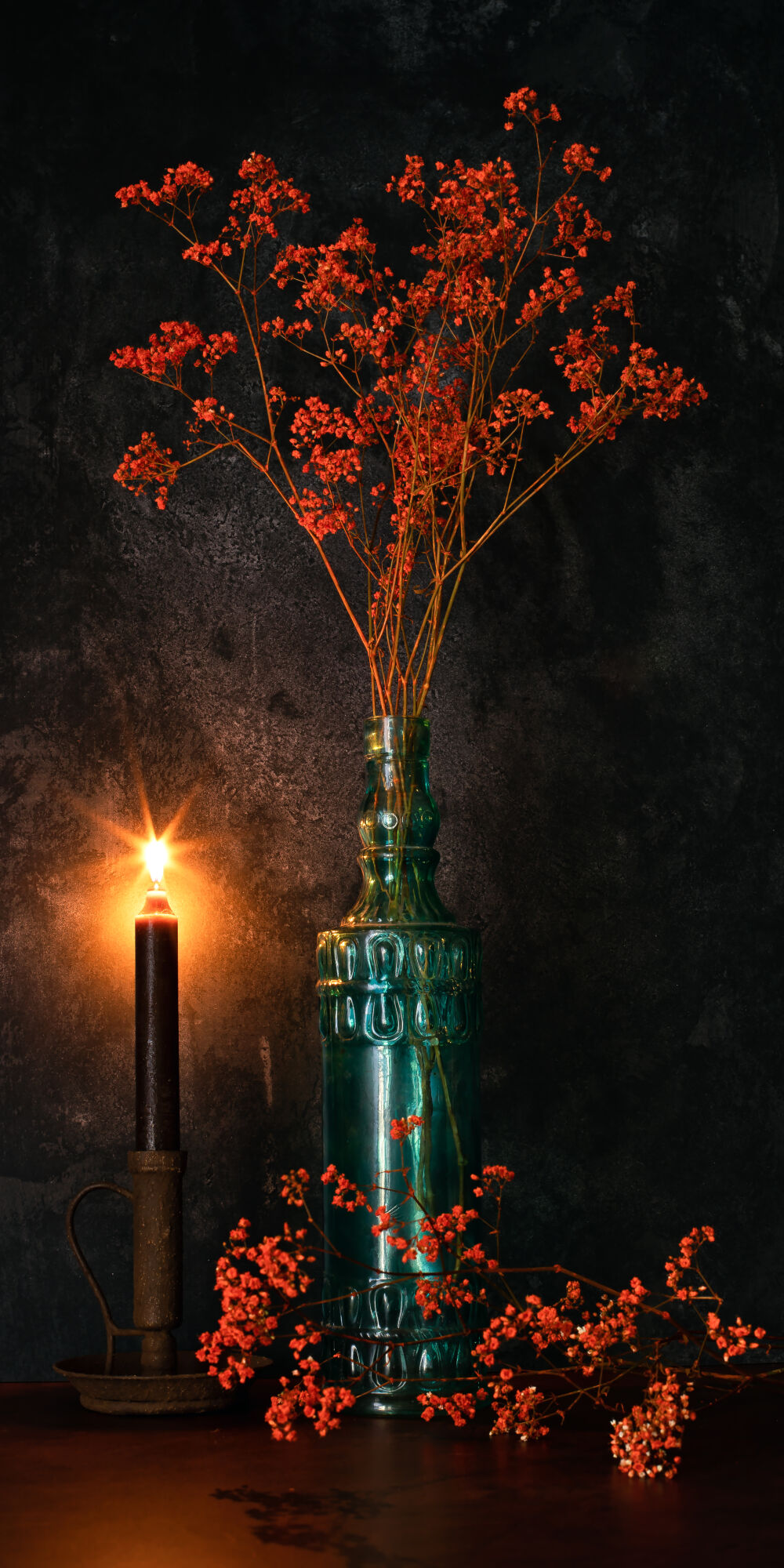 Orange Gypsophila in Blue Bottle with candlelight.