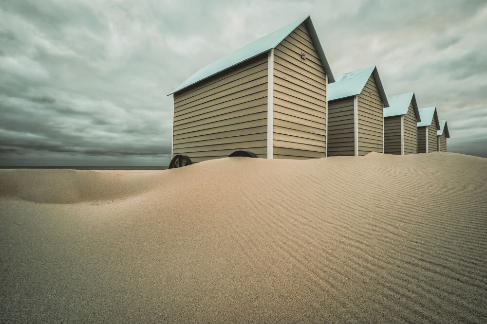 Strandcabines onder een dreigende lucht 