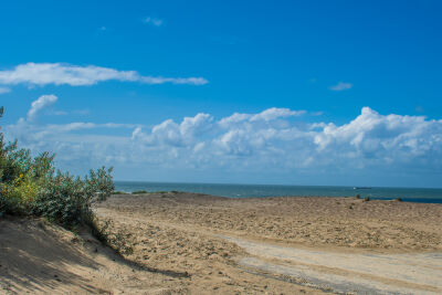 Cadzand-bad, het strand, de duinen, de zee en een blauwe lucht.
